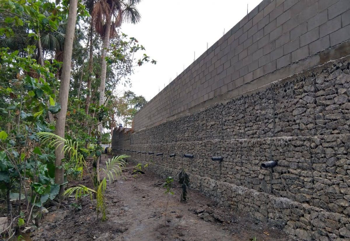 a wall with a brick wall and trees